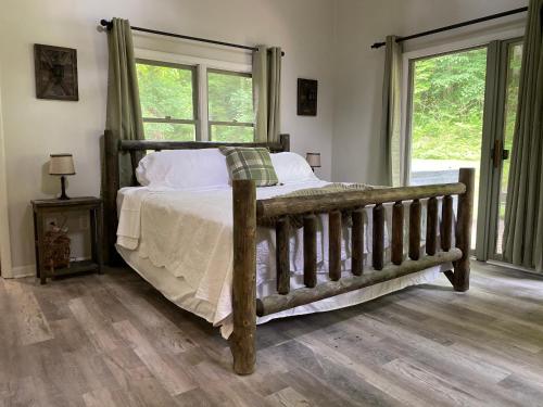 - une chambre avec un lit en bois et des fenêtres dans l'établissement The Hillbilly Hideaway with Hot Tub, Creek, & Outdoor Games, à Sevierville