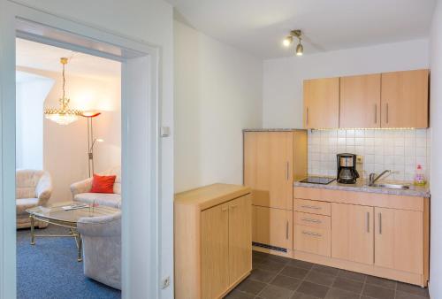 eine Küche mit Holzschränken und ein Wohnzimmer in der Unterkunft Zentrale Ferienwohnung 51qm im Hotel zur Börse in Hameln