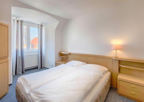 ein Schlafzimmer mit einem großen Bett und einem Fenster in der Unterkunft Zentrale Ferienwohnung 51qm im Hotel zur Börse in Hameln