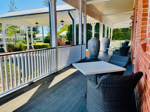 a porch with a white table and chairs at Ballina Manor Boutique Hotel in Ballina