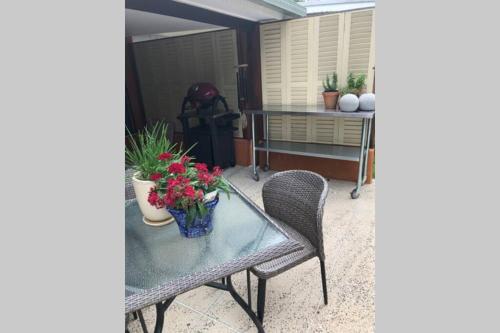 un tavolo in vetro con sedie e fiori di Daintree Beach Studio - BEACH FRONT ACCOMMODATION a Wonga
