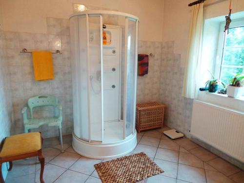 a bathroom with a shower with a chair and a table at Drengenberg in Hanerau-Hademarschen