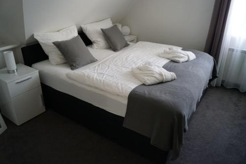 Schlafzimmer mit einem Bett mit weißer Bettwäsche und Kissen in der Unterkunft La Domus Premium Osnabrück Lotte in Gohfeld