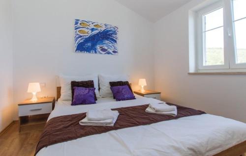 um quarto com uma grande cama branca com almofadas roxas em VillaBlu2 Doppelhaushälfte Fantastic Seaview, Pool em Zagorje