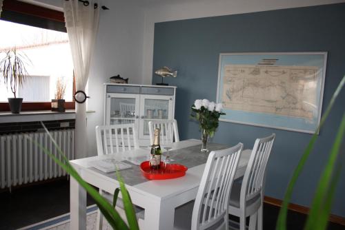 a dining room with a white table and white chairs at Ferienhaus am Nordostseekanal in Offenbüttel
