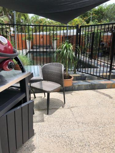 a patio with a chair and a table and a fence at Daintree Beach Studio - BEACH FRONT ACCOMMODATION in Wonga