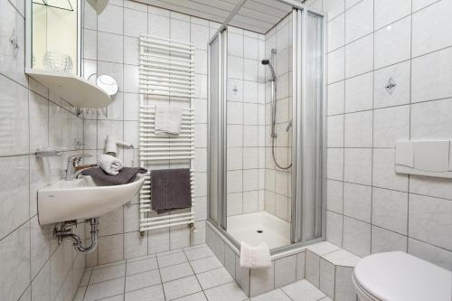 uma casa de banho branca com um lavatório e um chuveiro em Ferienhof Wuchner - Fewo "Frühlingserwachen" em Fröhnd