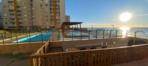 a view of a swimming pool on the balcony of a building at Apartamento CONFORT CLUB FRENTE MAR completo. in Barra Velha