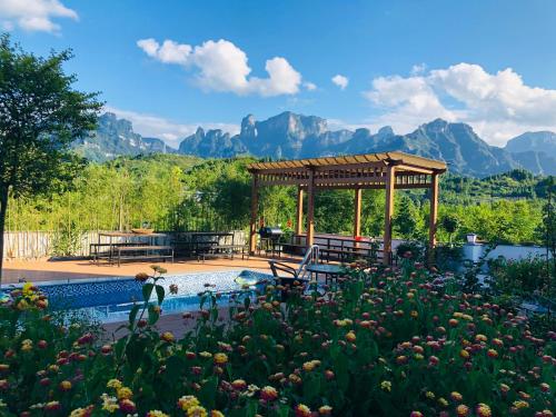 a swimming pool with a gazebo and mountains in the background at Heaven's Gate Home Stay in Zhangjiajie