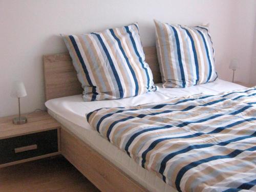 グレーミッツにあるFerienwohnungen Öker - Stadtvilla OGのベッド(青と白のストライプシーツ、枕付)