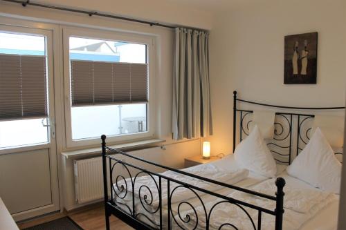 格洛米茨的住宿－"Wohnung 1 - G Pape" mit 2 Terrassen, kostenloses WLAN, Longstay Rabatt, Nähe Dünenpark，一间卧室配有带白色床单和枕头的床。