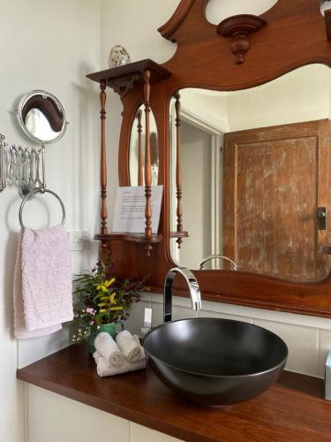 a bathroom with a black sink and a mirror at Aashay Country Stay in Fish Creek