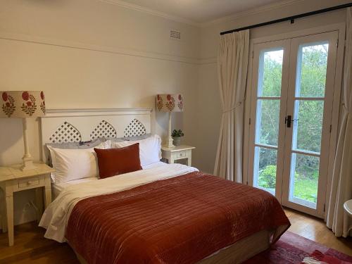 a bedroom with a bed and a large window at Aashay Country Stay in Fish Creek