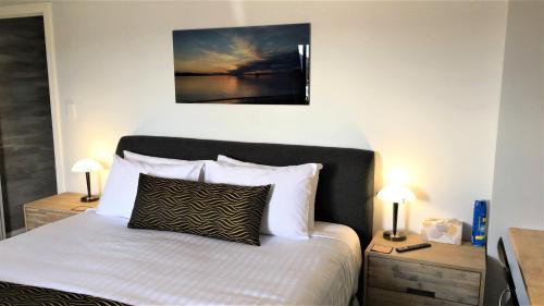 a bedroom with a bed with two night stands and two lamps at Storm Bay B&B in White Beach