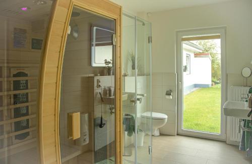 a bathroom with a shower and a toilet and a sink at Ferienhaus Sewald in Wulfen auf Fehmarn