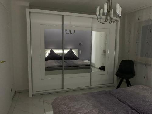 a bedroom with a mirrored wall with a bed in it at Moderne 2 Zimmer Wohnung mit Vollausstattung in Ketsch