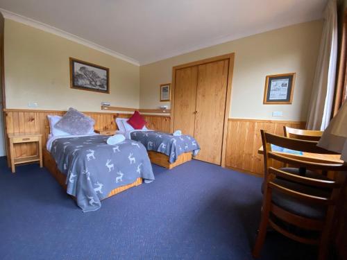 a bedroom with two beds with blue comforters at Candlelight Lodge in Thredbo