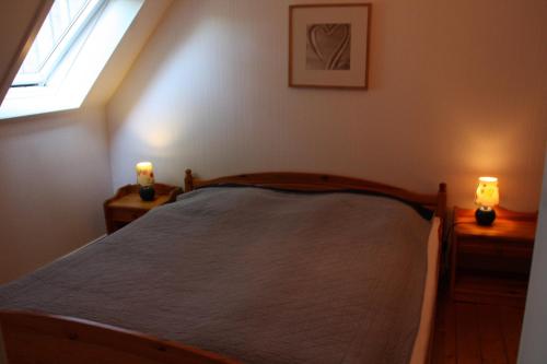 a bedroom with a bed and two candles on night stands at Muschelkorb in Hinrichsdorf