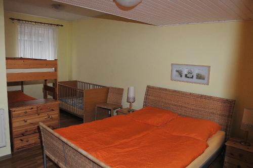 グレーミッツにあるFerienhof Kruse Wohnung 8のベッドルーム1室(オレンジ色の毛布付きのベッド1台付)