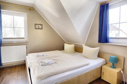 ツィングストにあるAm Deich 32の青い窓が備わるドミトリールームのベッド1台分です。