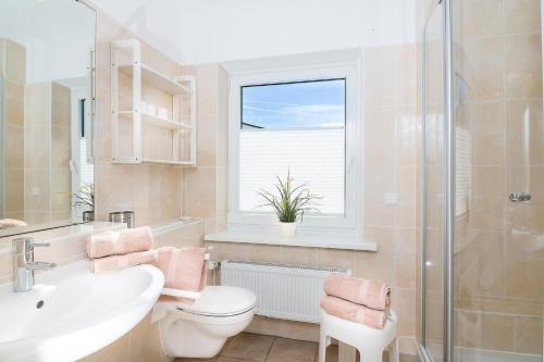 ein Bad mit einem WC, einem Waschbecken und einem Fenster in der Unterkunft M2 - Apartmenthaus Marienburger Str 4 - FERIENDOMIZIL HOLLICH in Grömitz