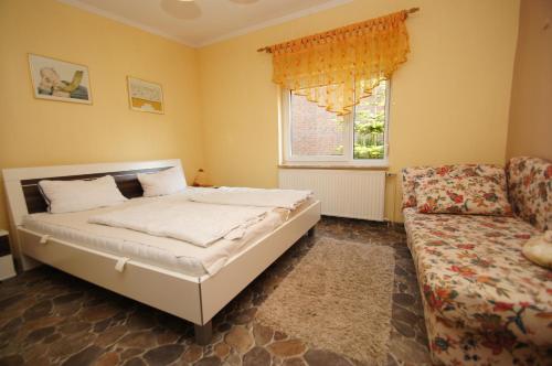ein Schlafzimmer mit einem Bett, einem Sofa und einem Fenster in der Unterkunft Rudow in Dahme