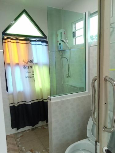 un bagno con tenda da doccia e WC di บ้านแช่มช้อย 360 a Khao Kho