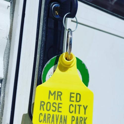 a yellow mr ed rose city caravan park sign on a door at Rose City Caravan Park in Warwick