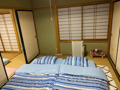 a bedroom with two beds in a room with windows at Mount Fuji Castle 2 in Yamanakako