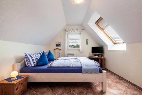 - une chambre avec un lit doté de draps bleus et une fenêtre dans l'établissement Ostsee-Schwänchen II, à Gollwitz