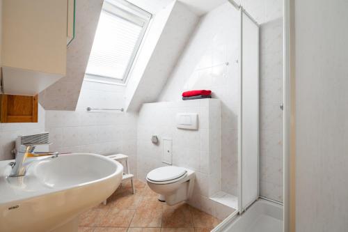 La salle de bains blanche est pourvue de toilettes et d'un lavabo. dans l'établissement Ostsee-Schwänchen II, à Gollwitz