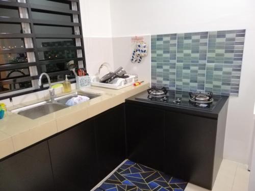 a kitchen with a sink and a stove at Onies Homestay Lumut Manjung in Lumut
