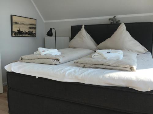 a bed with white sheets and pillows on it at Ostsee - Reetdachhaus Nr 46 "Strandrausch" im Strand Resort in Heiligenhafen