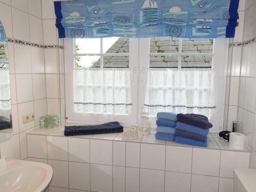 a bathroom with a window with towels on a shelf at Tante Anna in Hasselberg