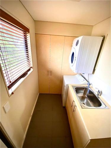 a small kitchen with a sink and a window at Pedder Wilderness Lodge in Strathgordon