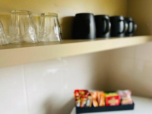 a shelf with wine glasses and a box of candies at Pedder Wilderness Lodge in Strathgordon