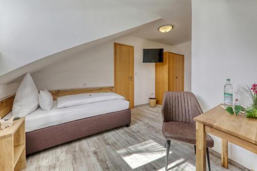 a bedroom with a bed and a table and a chair at Hotel Waldfrieden "Das kleine Hotel" in Spiegelau