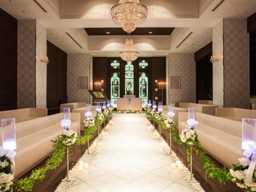 a wedding aisle in a church with white flowers at Hotel Monterey Edelhof Sapporo in Sapporo