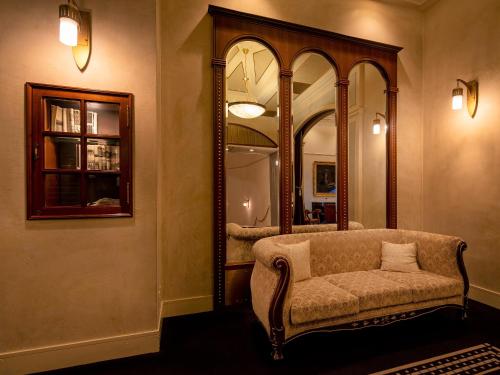 a living room with a chair and a mirror at Hotel Monterey Edelhof Sapporo in Sapporo