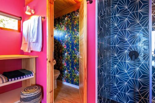 Habitación rosa con baño con ducha. en Lagoon Studio - Fantastic Knysna Lagoon views and SOLAR in self-catering studio, en Knysna