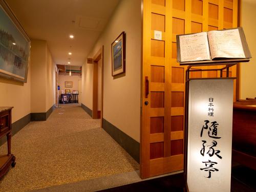 a hallway with a door with writing on it at Hotel Monterey Edelhof Sapporo in Sapporo