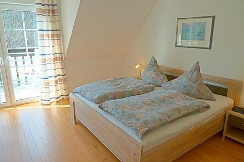 een slaapkamer met een bed en een groot raam bij Sonnenpalais in Zingst