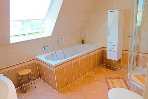 a bathroom with a tub and a toilet and a sink at Sonnenpalais in Zingst