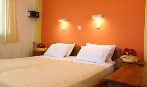 1 dormitorio con 1 cama con pared de color naranja en Nama Apartments, en Skala Potamias