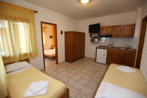 a room with two beds and a kitchen with a kitchen at Nama Apartments in Skala Potamias