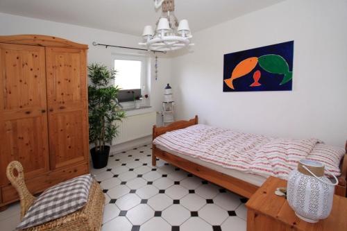 a bedroom with a bed and a cabinet and a chair at Ferienwohnung Strandgut in Behrensdorf