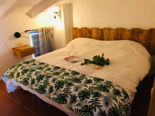 una camera da letto con un letto con un copriletto e piante sopra di vtar la veguilla a Polvillar