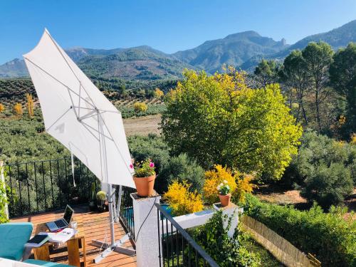 a white umbrella on a deck with mountains in the background at vtar la veguilla in Polvillar