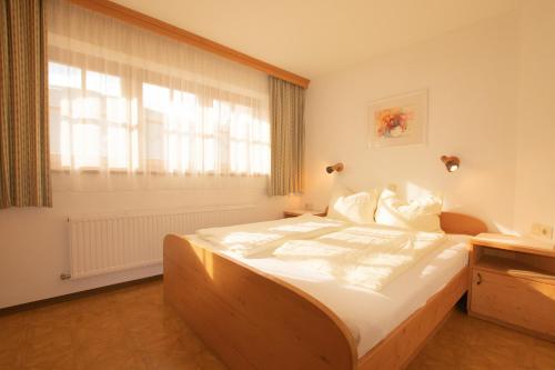 a bedroom with a large bed and a window at Schoners Einfanghof WILD005 in Niederau