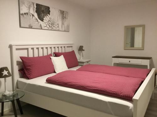 オッフェンブルクにあるFerienwohnung Casa Biancaのベッドルーム1室(赤と白の枕が備わるベッド1台付)